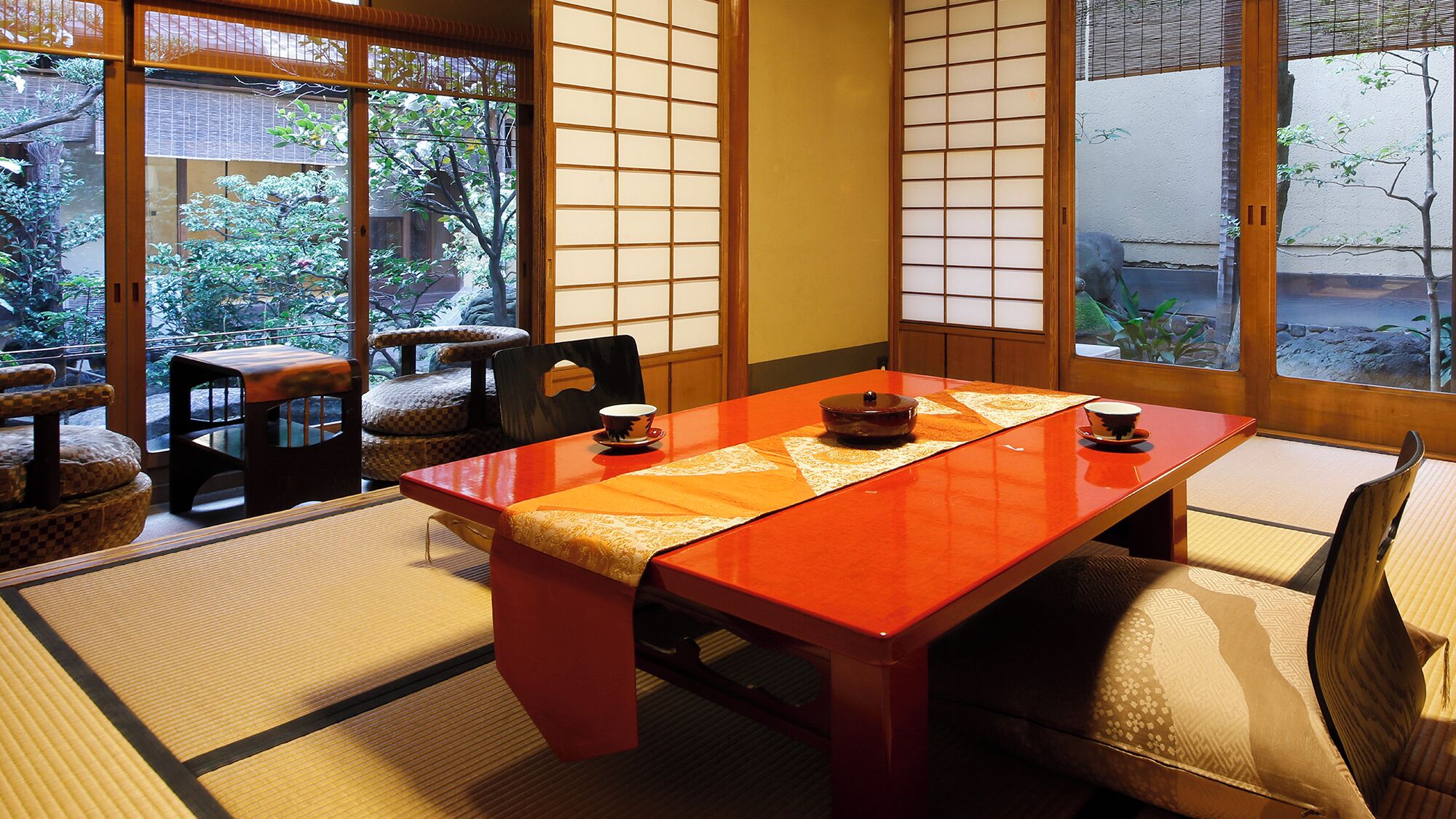 A traditional Japanese room with tatami flooring, a low table, and shoji screens.