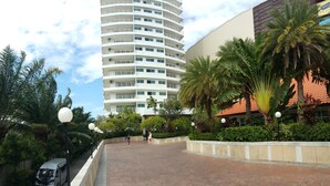 A modern building with multiple balconies, surrounded by lush greenery and palm trees. - Vtsix Condo Service at View Talay Condo (Pattaya)