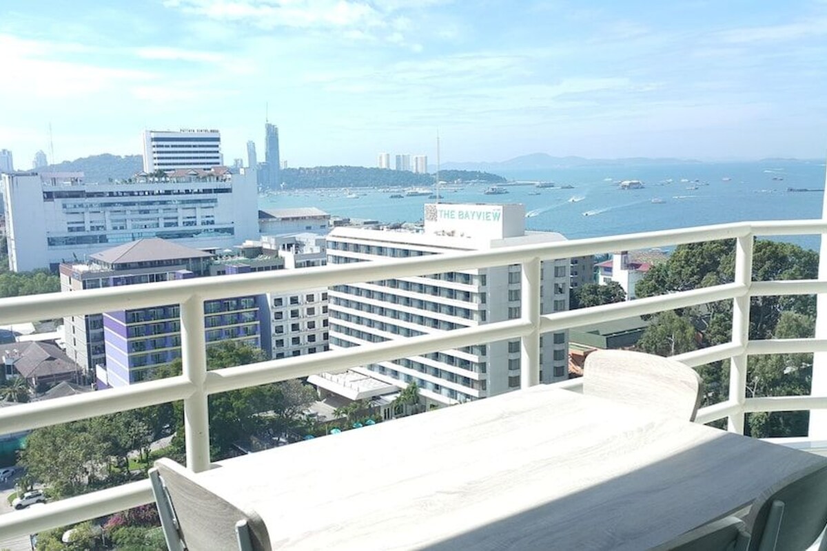 A high-rise building with a view of a marina and cityscape.