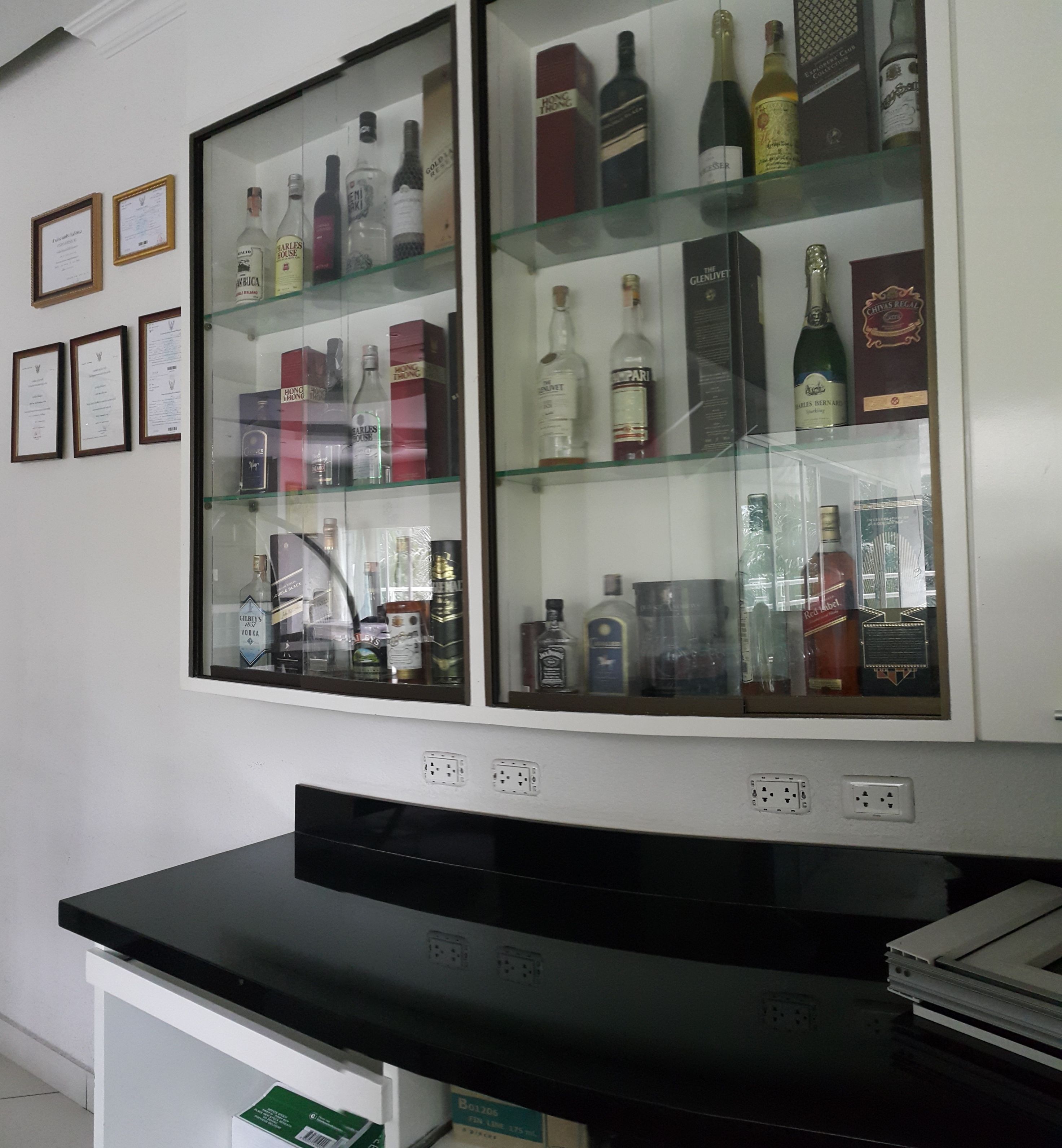 Une vitrine contenant diverses bouteilles et bouteilles de spiritueux, ainsi que des boîtes.