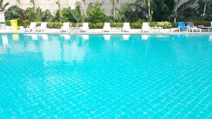 A clear blue pool with white lounge chairs and a yellow trash bin. - Vtsix Condo Service at View Talay Condo (Pattaya)