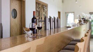 A bar area with a wooden counter, two wine glasses, and a bottle of wine. - Hotel & Restaurant die Linde (Wangen)