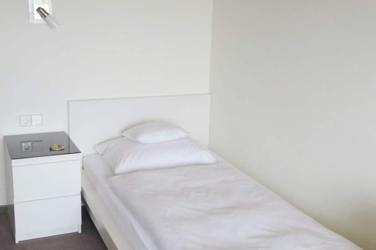 Habitación individual económica | Escritorio, tabla de planchar con plancha, cunas y camas extra