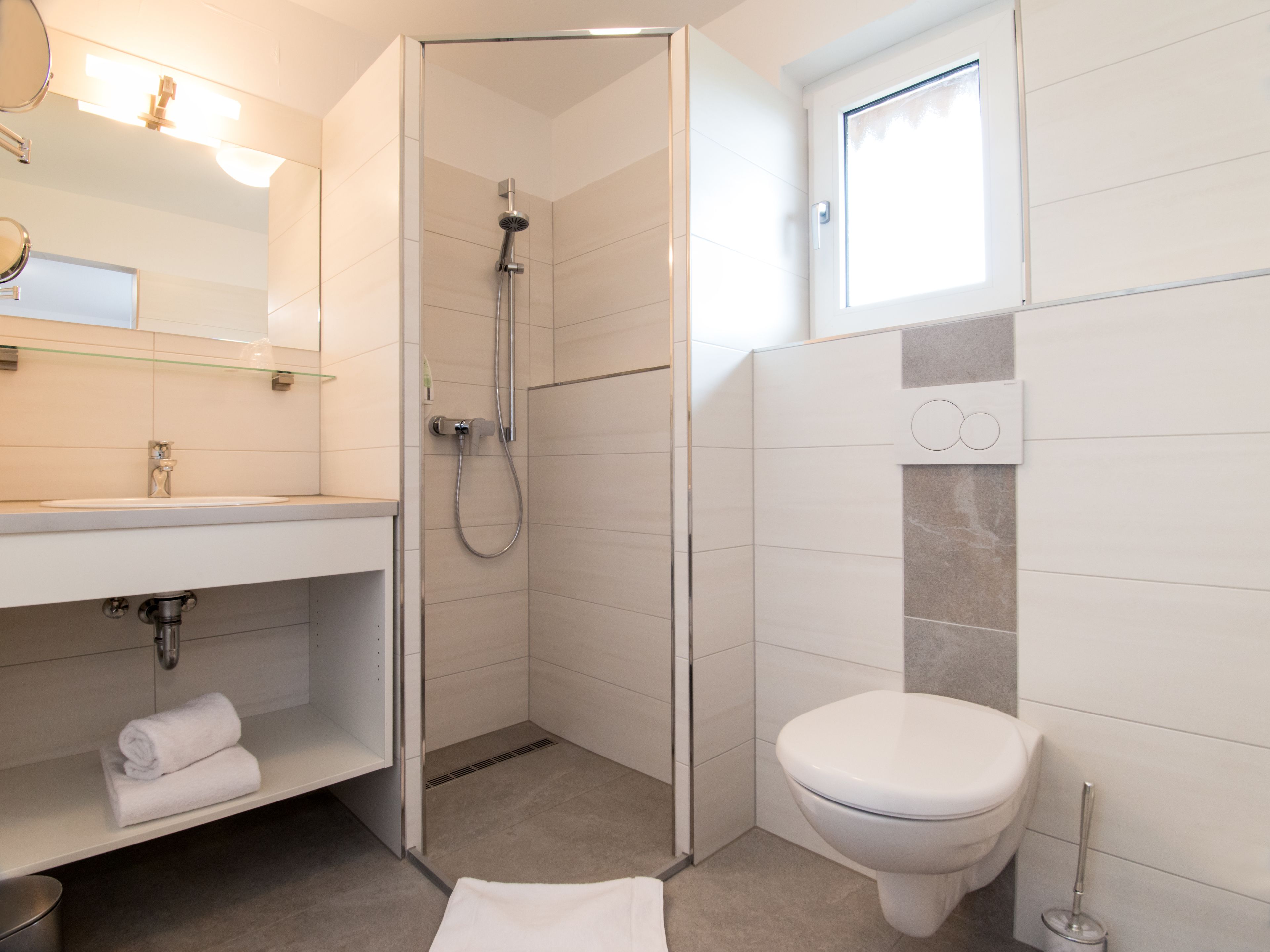 Ein modernes Badezimmer mit Dusche, Toilette und Waschbecken.