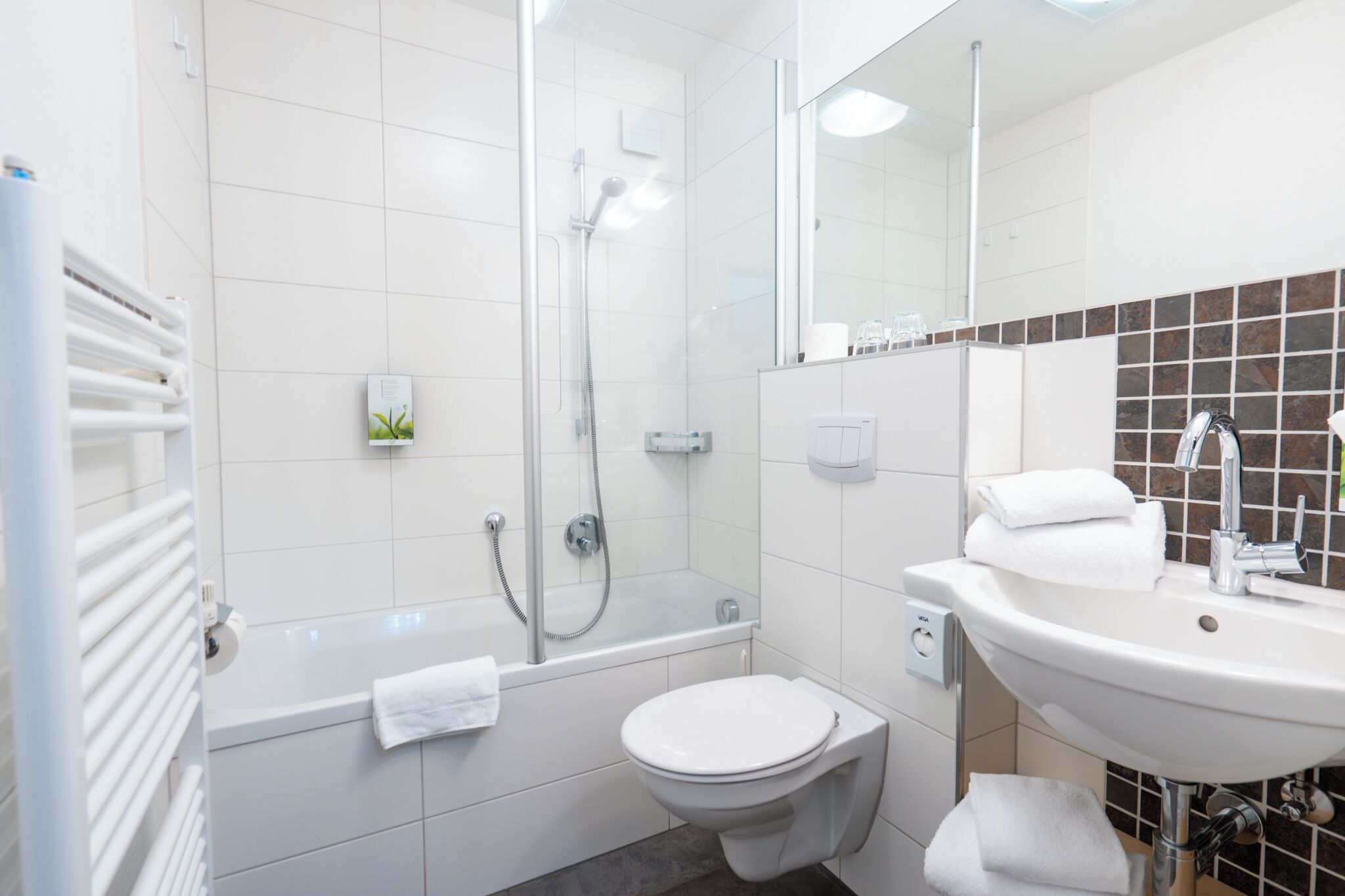 Une salle de bain moderne équipée d’une baignoire, de toilettes et d’un lavabo.