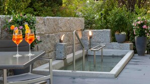 An outdoor seating area with a pool, stone walls, and potted plants. - Wellnesshotel Sonnenhof & Sonnhalde (Uehlingen-Birkendorf)