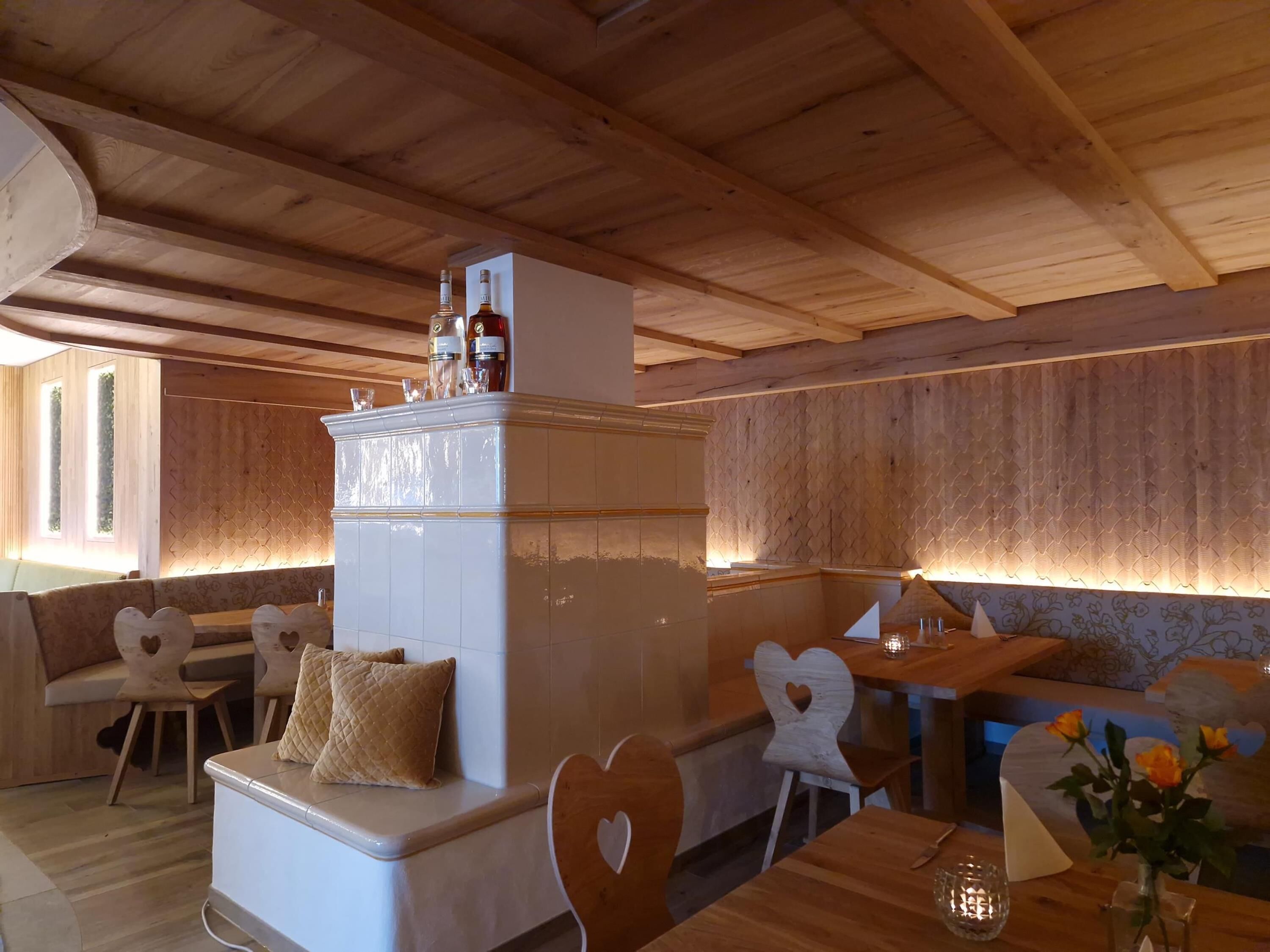 A cozy, wooden interior with a central seating area, a small bar area, and a decorative cabinet with bottles.