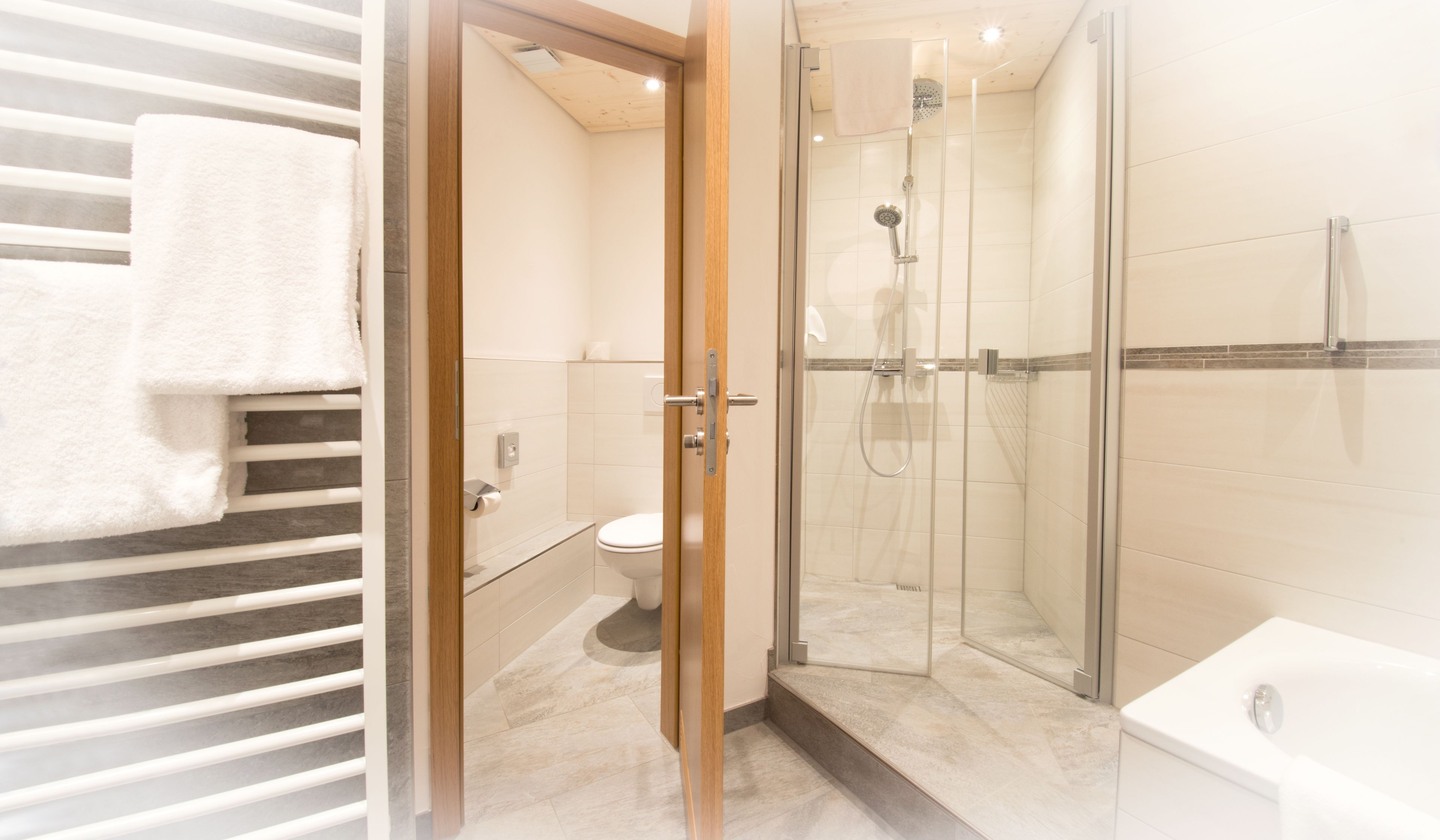 Une salle de bain moderne avec une douche à parois de verre, des toilettes et une baignoire.