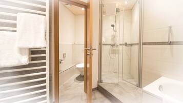 Une salle de bain moderne avec une douche à parois de verre, des toilettes et une baignoire.