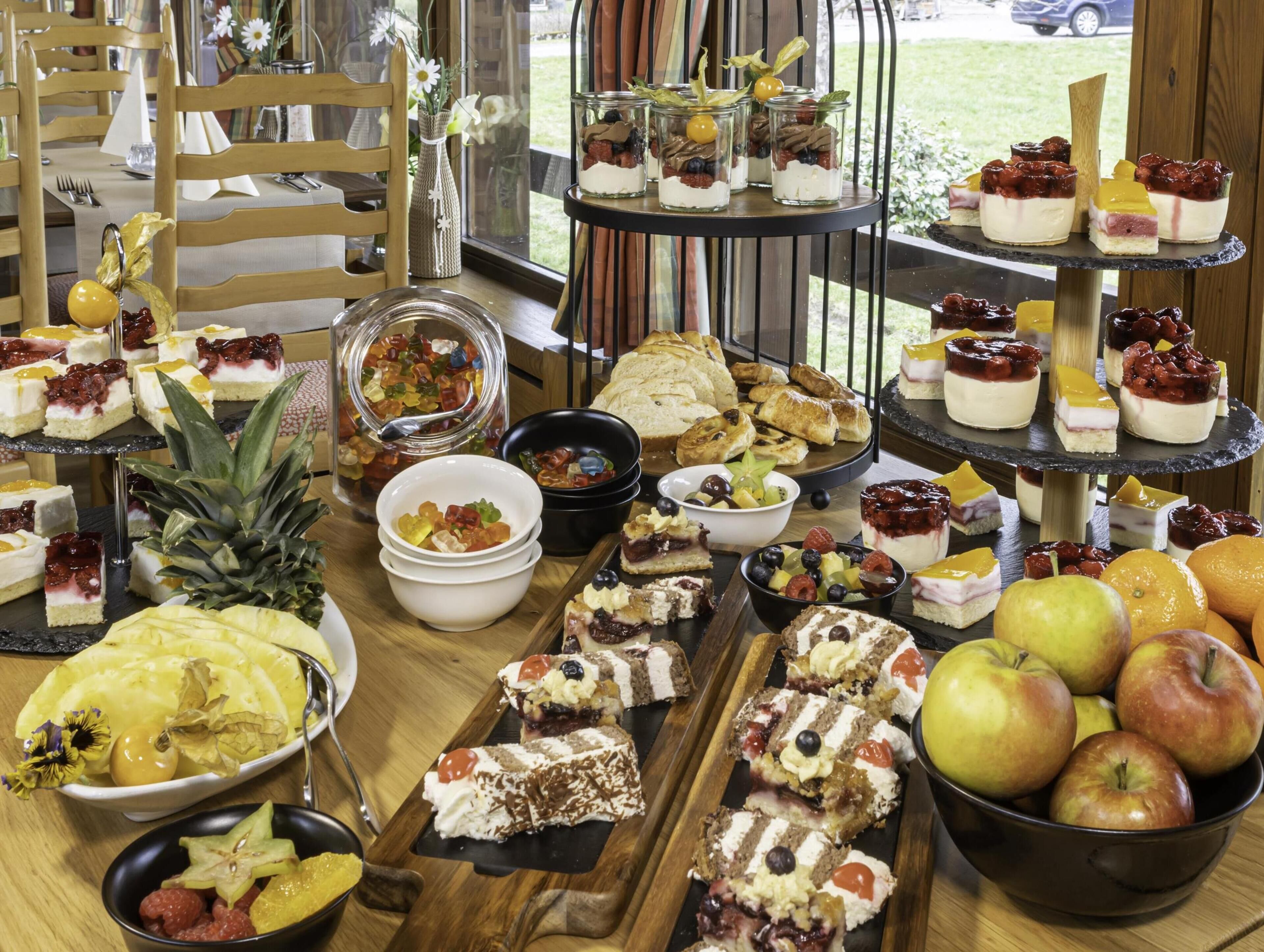 Una mesa de buffet con diversos postres y frutas.