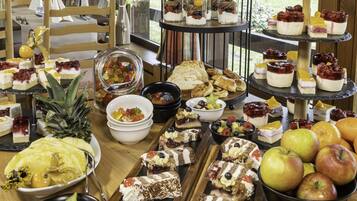 Una mesa de buffet con diversos postres y frutas.