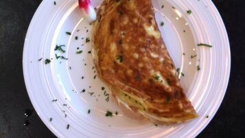 A plate with a folded omelette garnished with herbs.