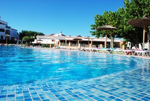 Una piscina al aire libre, sombrillas, tumbonas