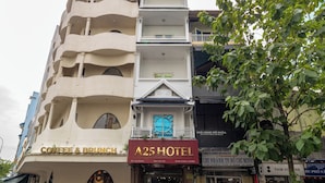 A multi-story hotel with a coffee shop on the ground floor, a prominent A25 HOTEL sign, and a visible entrance with a motorcycle parked outside.