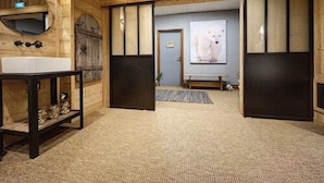 A wooden interior with a sink, bench, and a polar bear painting.