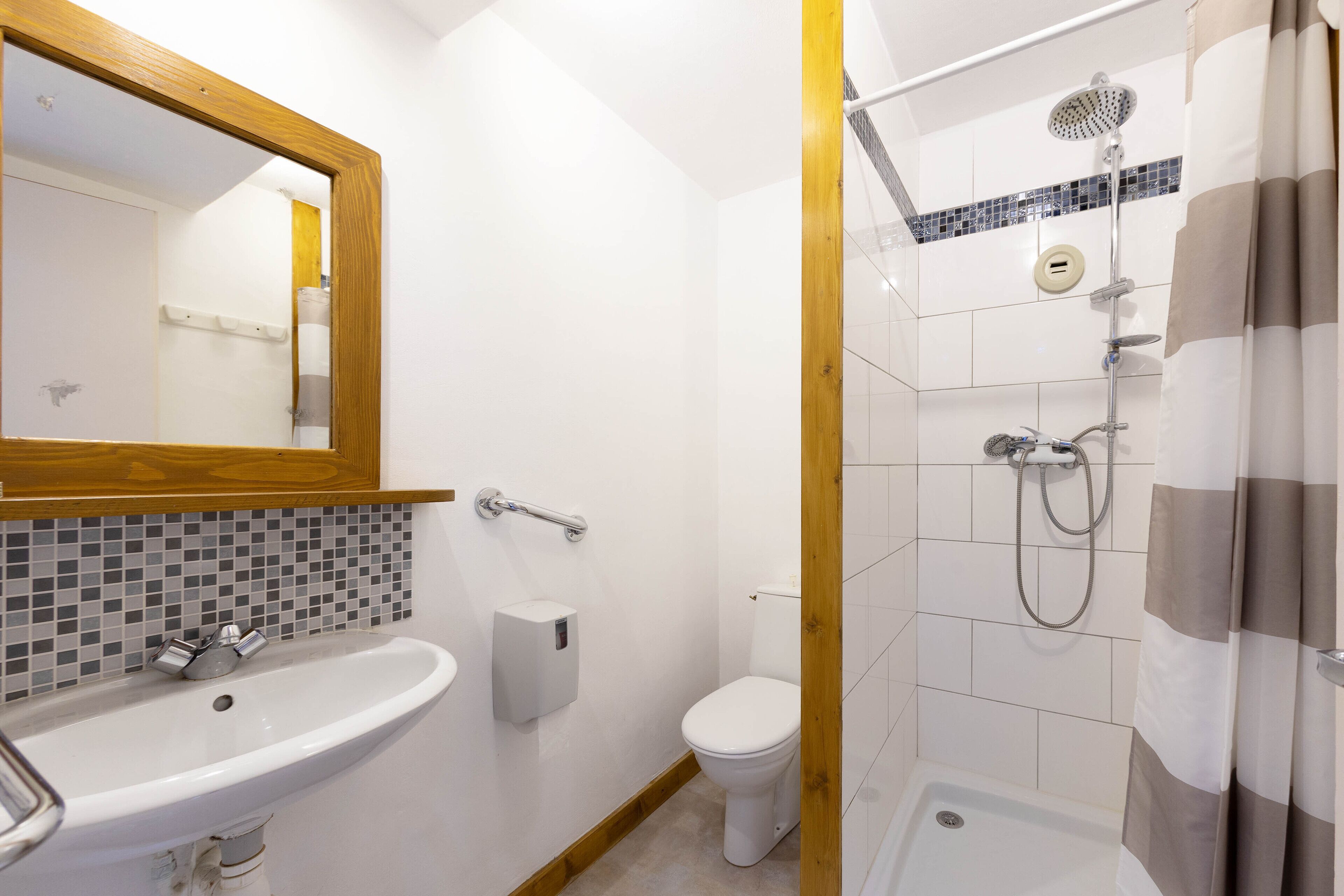 Une salle de bain avec un lavabo, des toilettes et une douche.