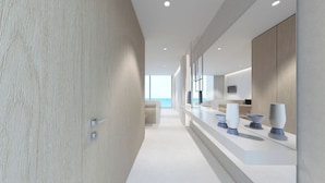 A modern hotel corridor with a wooden wall, a seating area with a view, and a counter with decorative bowls. - Kos Aktis Art Hotel (Kos)