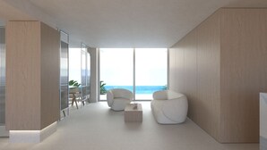 A modern living room with a large window, a sofa, a coffee table, and a view of the ocean. - Kos Aktis Art Hotel (Kos)