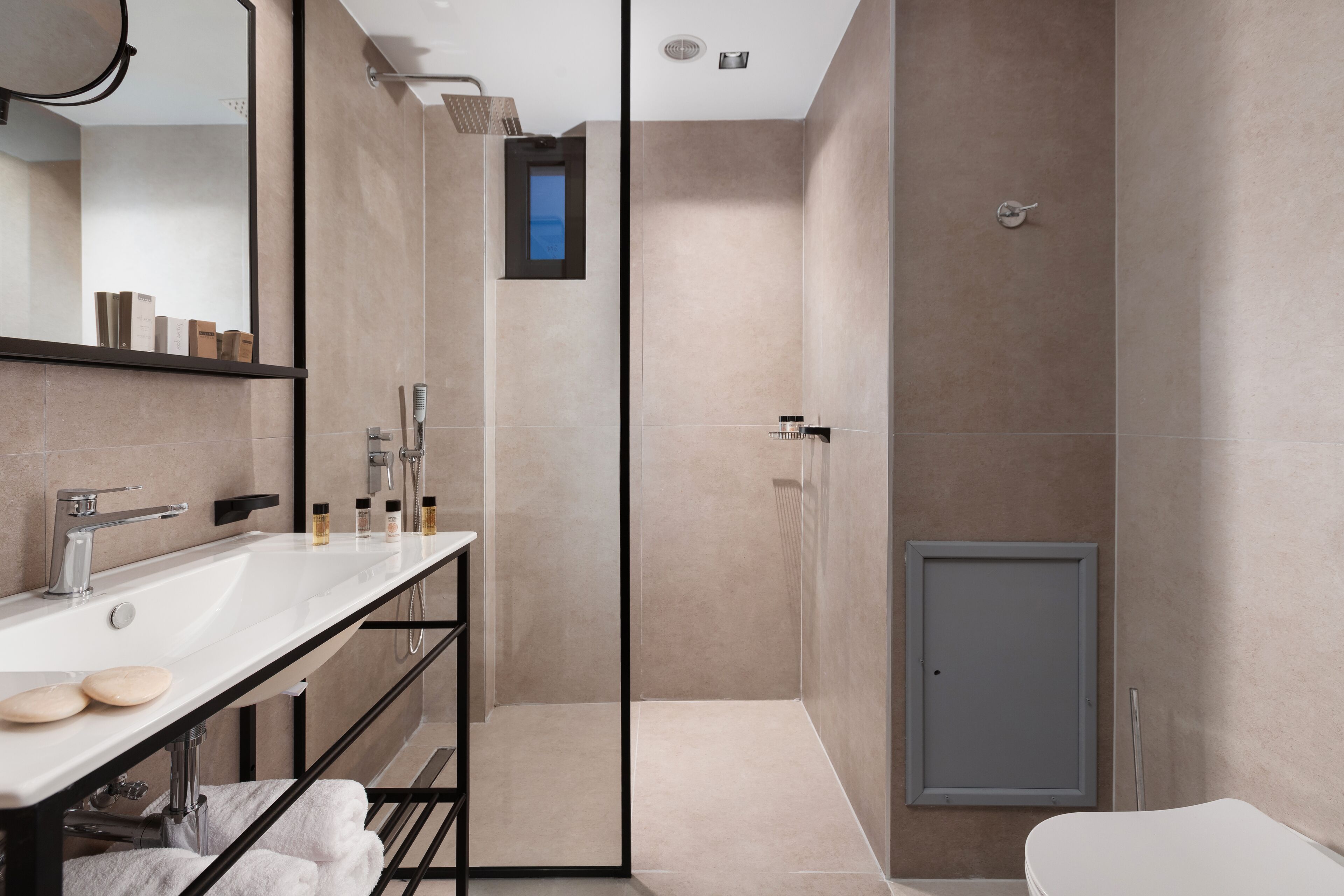 Un baño moderno con un tocador amplio, una ducha y un inodoro.