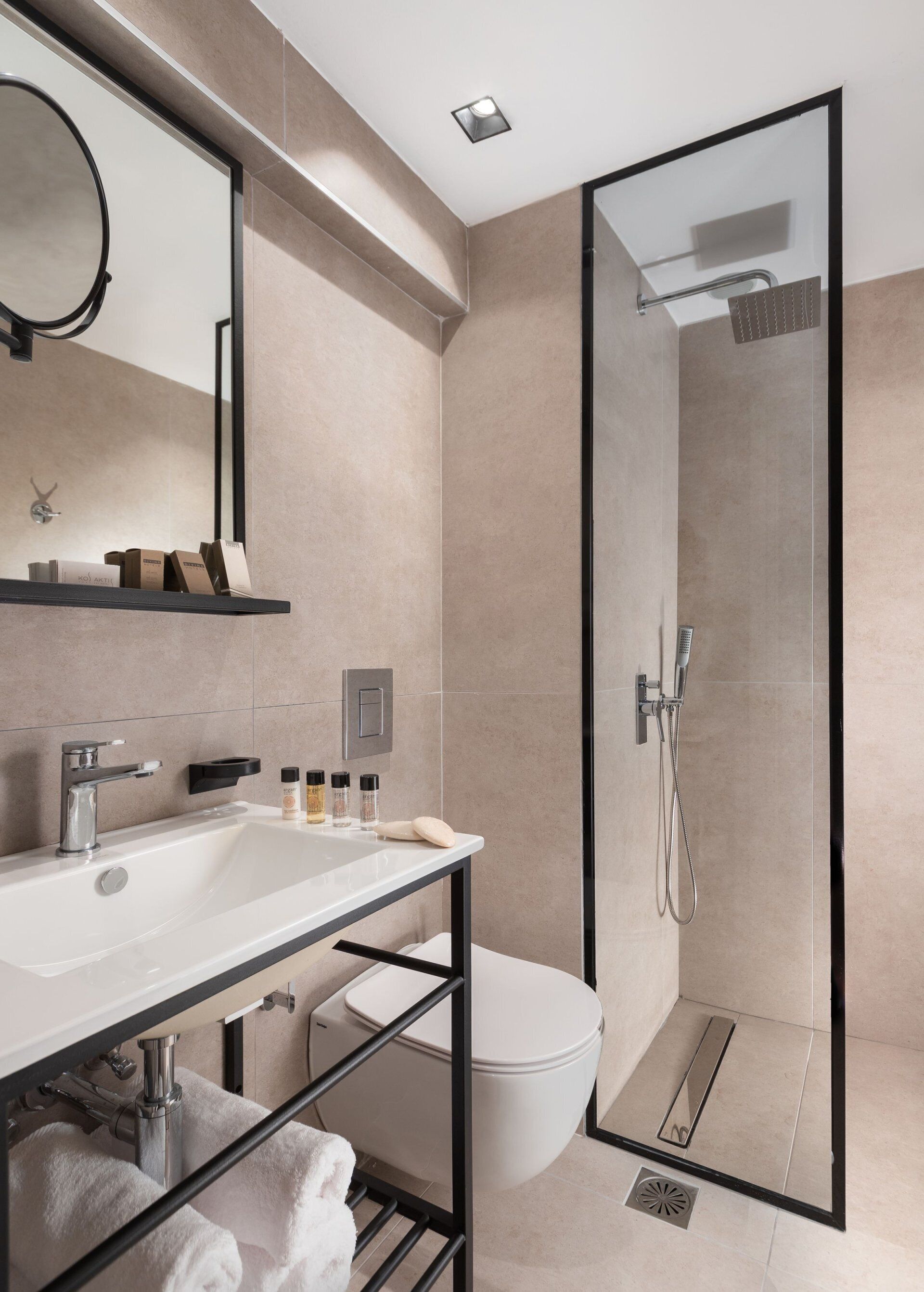 A modern bathroom with a glass-enclosed shower, a white sink, and a toilet.