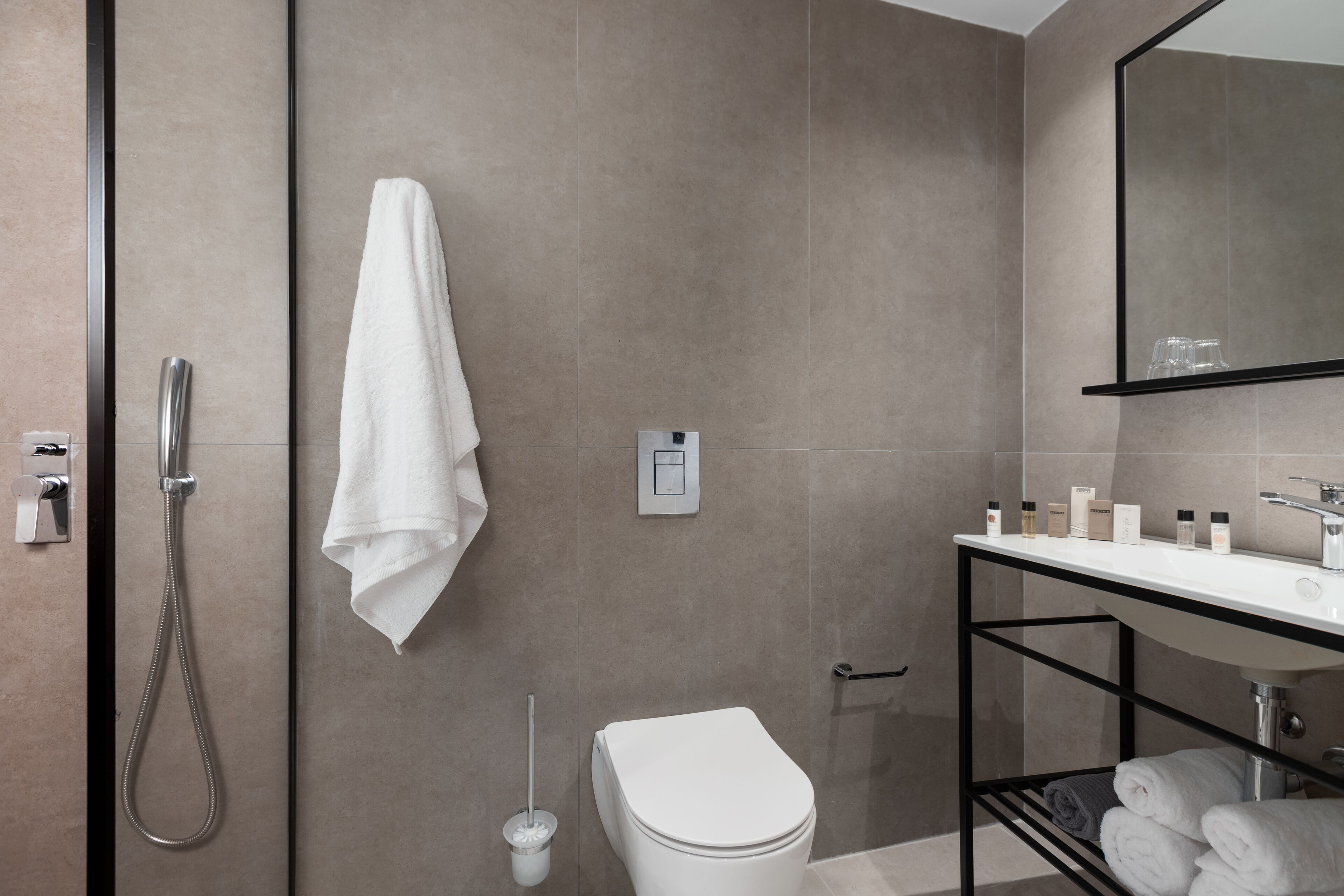 Une salle de bain moderne équipée d’une douche, de toilettes et d’un lavabo.
