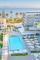 Una piscina al aire libre, sombrillas, sillones reclinables de piscina