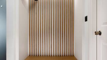 A compact room with a built-in bench, vertical blinds, and a ceiling-mounted light fixture.