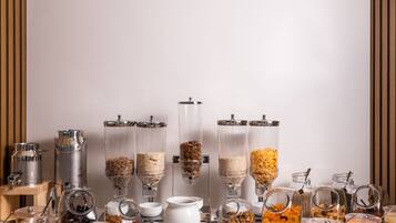 Un buffet allestito con diversi contenitori e distributori di cibo.
