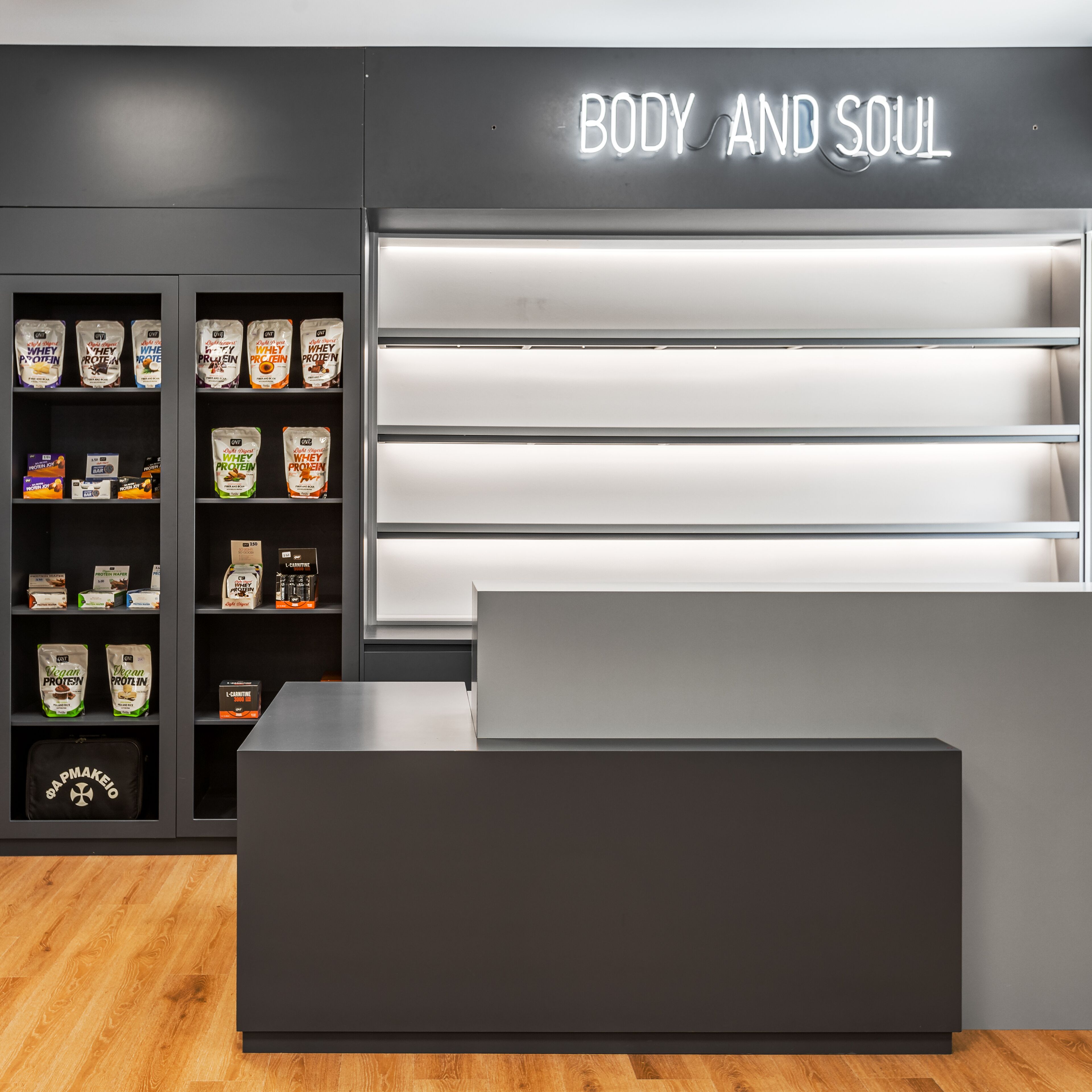 A modern fitness center with a reception desk and shelves stocked with protein products.