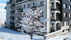 A multi-story hotel with balconies and a snow-covered landscape. - All Seasons Club (Bansko)