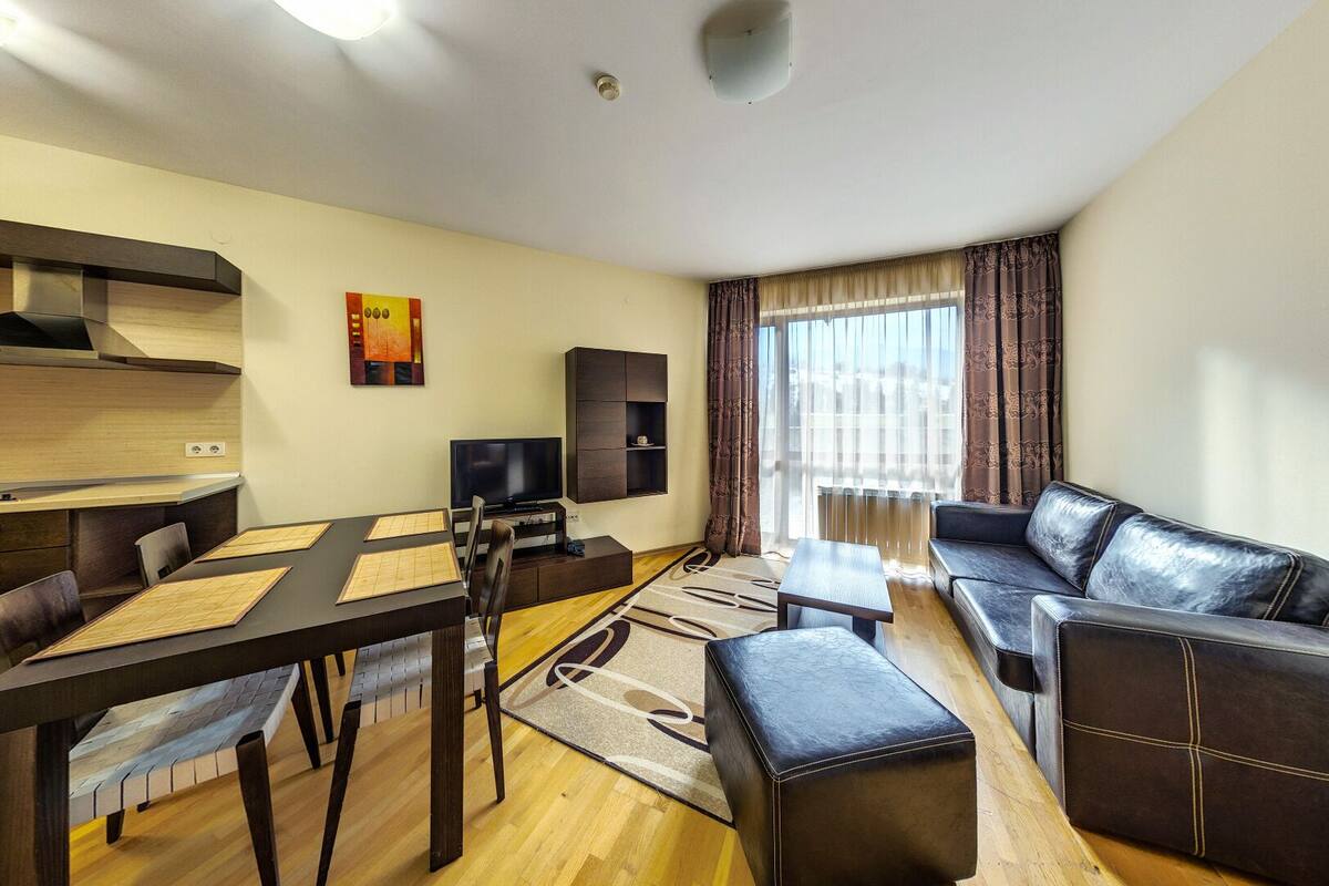 Una sala moderna con una mesa de comedor, sofá y televisor.