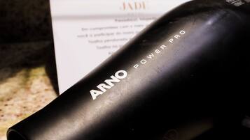 Un secador negro con el nombre de la marca 'ARNO' sobre una encimera de granito.