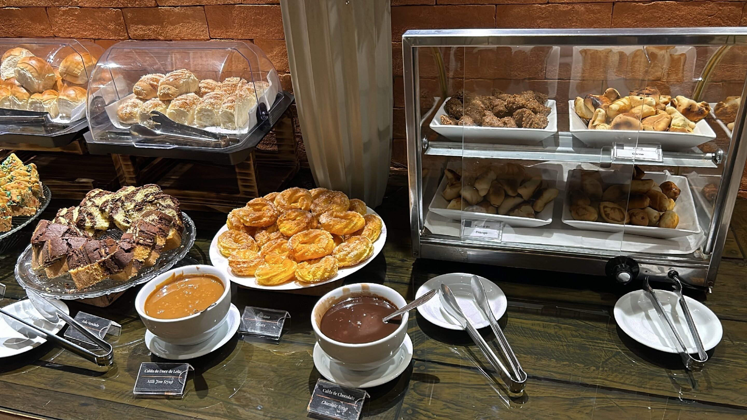 A buffet with various food items including pastries, desserts, and chocolate sauces.