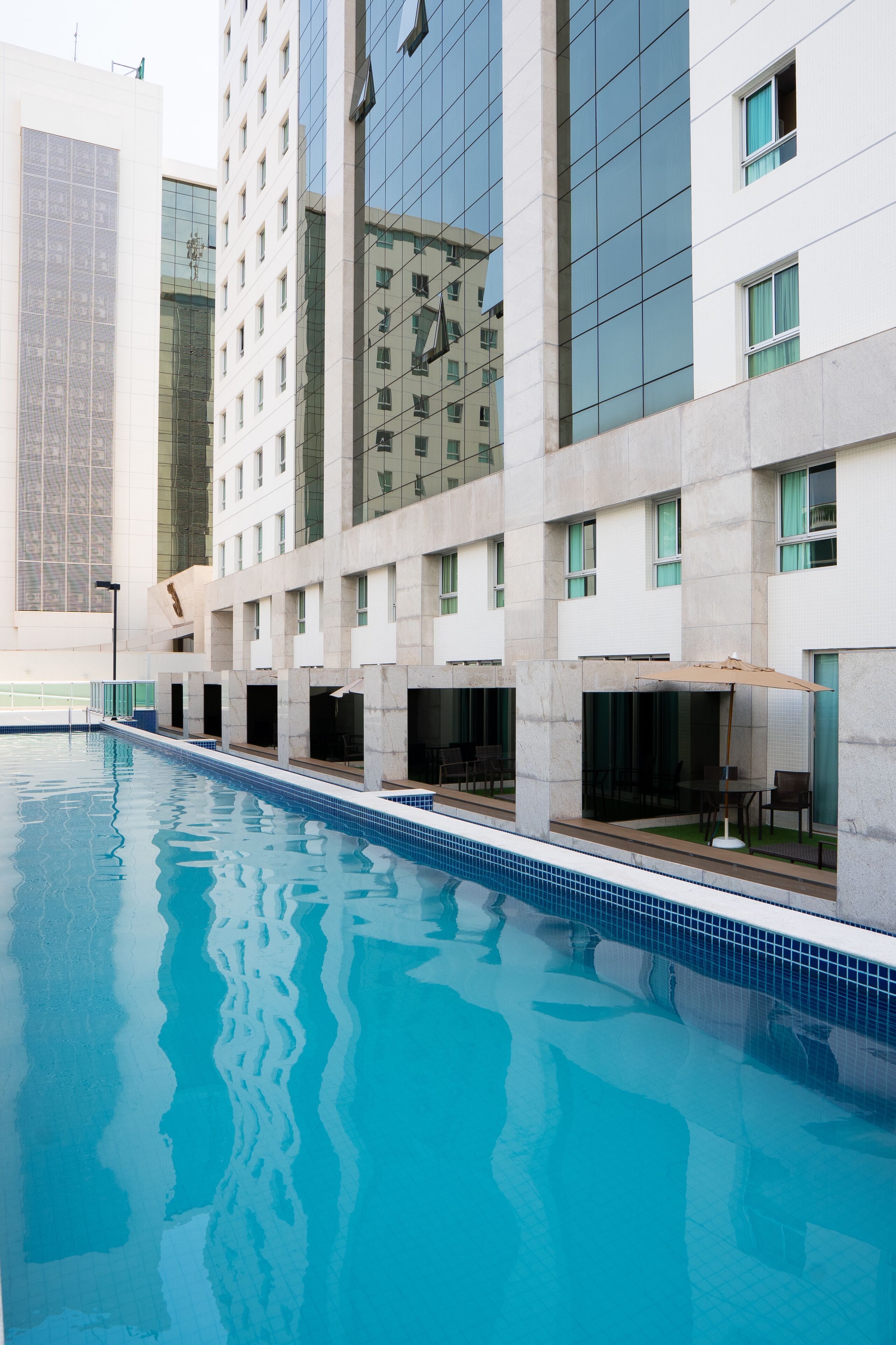 Um hotel moderno com piscina, grandes janelas e um design limpo e contemporâneo.