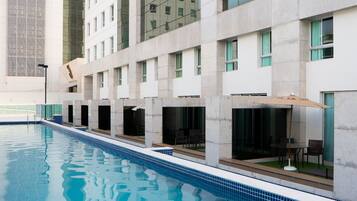 Um hotel moderno com piscina, grandes janelas e um design limpo e contemporâneo.