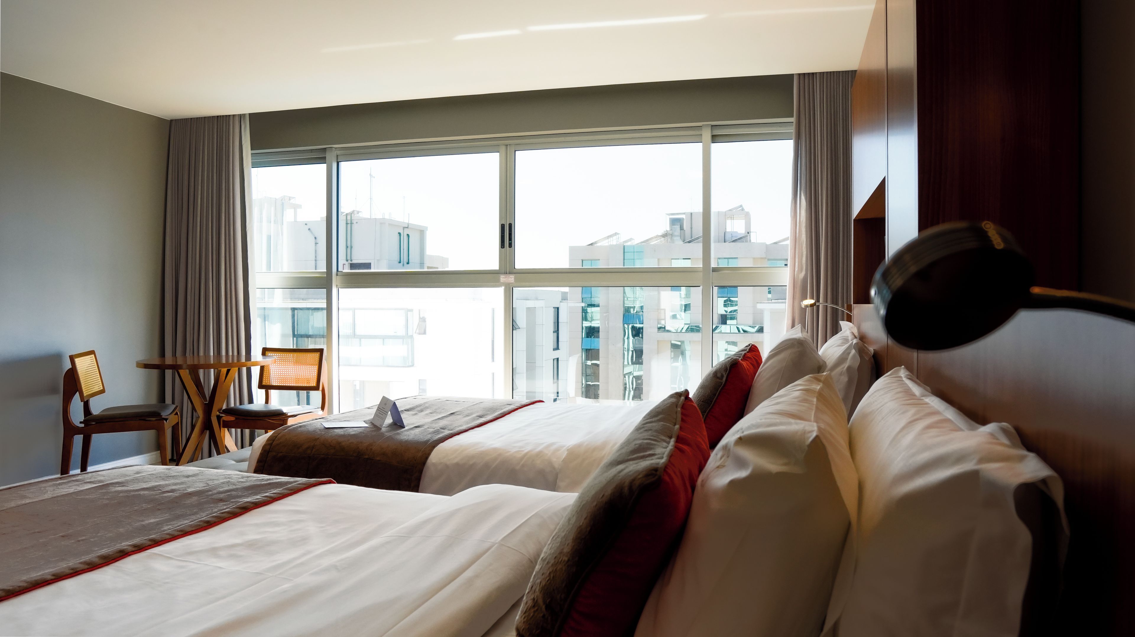 Habitación de hotel con dos camas, un escritorio y una silla.