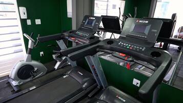 Un gimnasio con cintas de correr y una máquina elíptica.