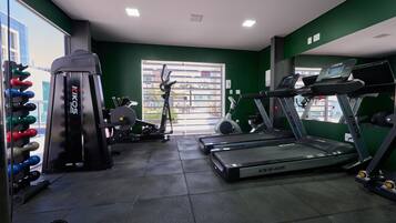 A gym with treadmills, weight machines, and dumbbells.