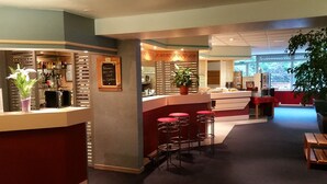 A hotel lobby with a reception desk, bar area, and seating. - Hôtel Inn Design Moutiers (Moutiers)