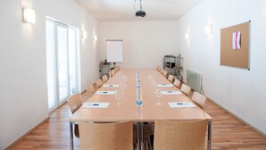 A conference room with a long table, chairs, a projector, and a whiteboard. - Hotel Restaurant Hohberg (Schaffhausen)