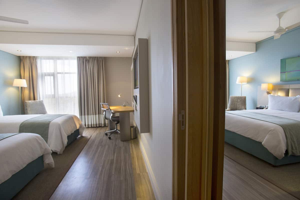 Une chambre d’hôtel avec deux lits, un bureau et une chaise.