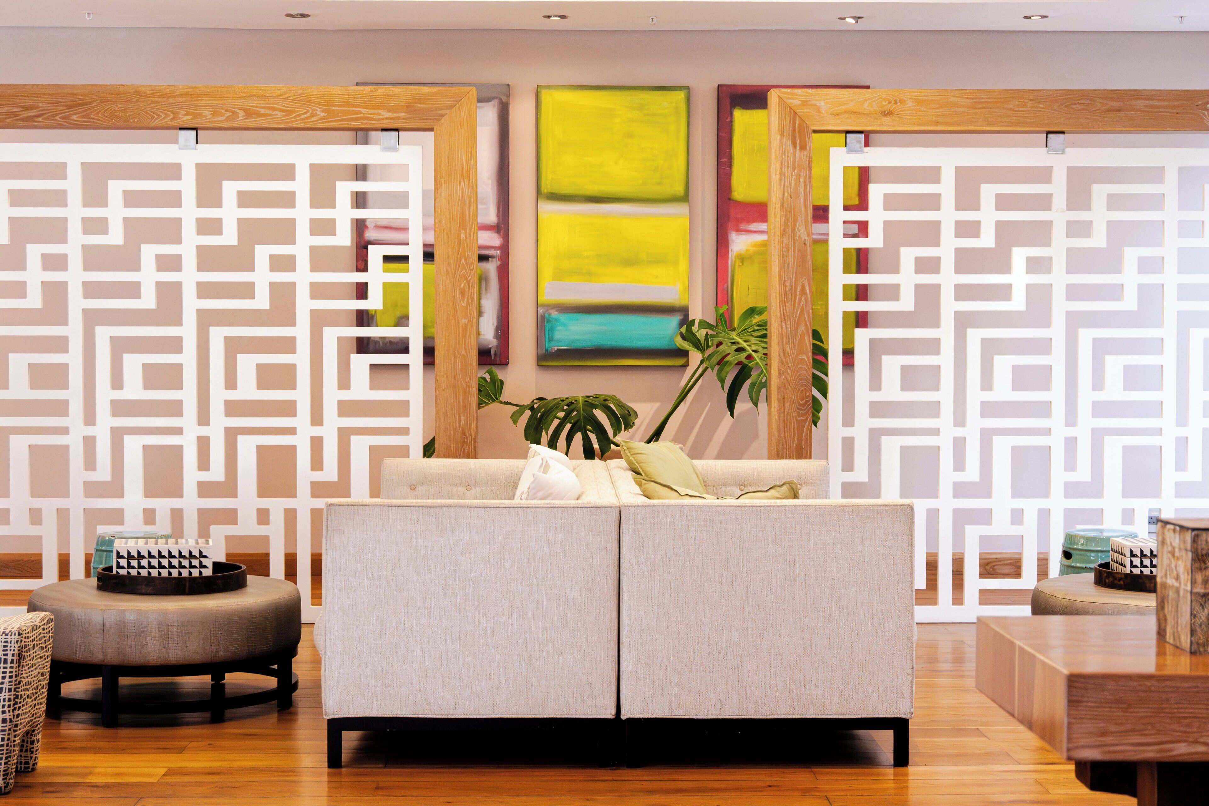 A modern living room with a sofa, ottoman, and decorative items.