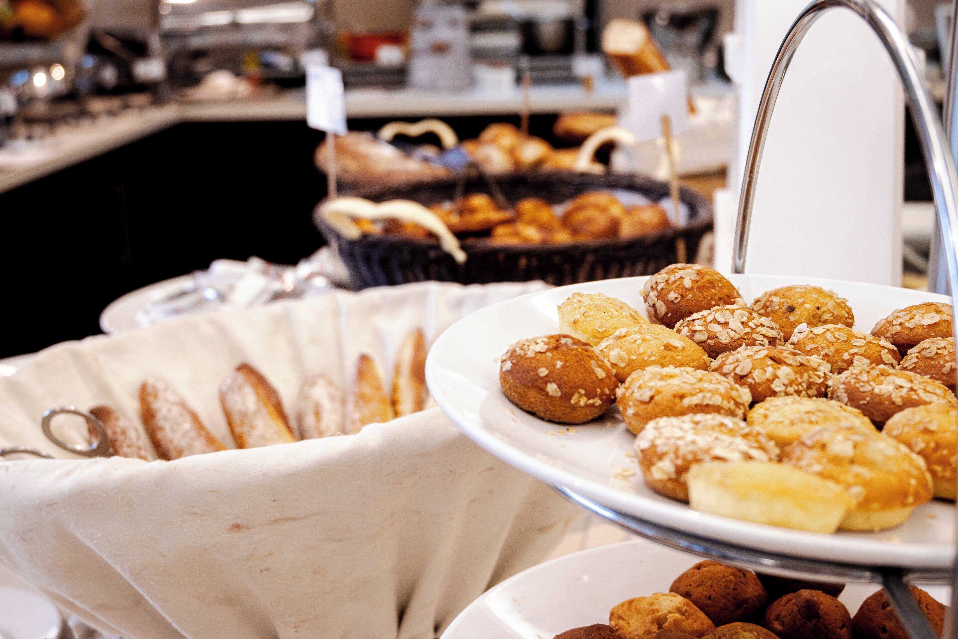 A buffet with various baked goods including pastries and bread.