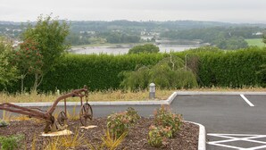 A parking area with a view of a river and distant buildings. - Samuel's Heritage Bed & Breakfast (Waterford)