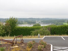 A parking area with a view of a river and distant buildings.