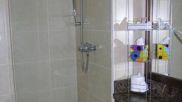 A bathroom with a shower, toilet, and a vanity with a mirror.