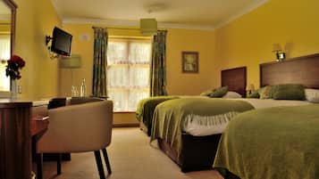 A hotel room with two beds, a desk, a chair, a television, and a window with curtains.
