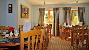 A dining area with wooden furniture, a clock, and a painting on the wall. - Samuel's Heritage Bed & Breakfast (Waterford)