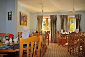 A dining area with wooden furniture, a clock, and a painting on the wall.