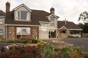 A two-story house with a stone facade, large windows, and a garage.